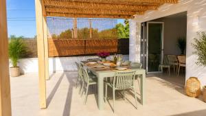a dining table and chairs on a patio at Hermosa casa con piscina cerca de la playa de Punta Prima in Punta Prima