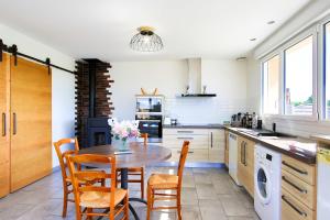 a kitchen with a table and chairs and a stove at Studio Le Jardin in Lison +8 photos