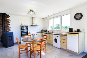 a kitchen with a table and chairs and a kitchen with a stove at Studio Le Jardin in Lison
