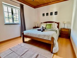 a bedroom with a bed with a teddy bear on it at Égua Nature House in Piódão