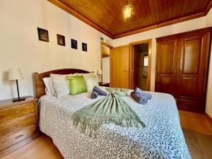a bedroom with a bed and a wooden ceiling at Égua Nature House in Piódão
