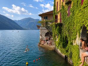 a group of people swimming in a body of water at Panorama Lake Relax in Nesso