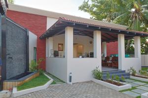 a small house with a red brick wall at MHOMES Resort - Madurai in Alagar Kovil