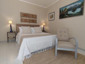 a bedroom with a large bed and a chair at La Chicca nel Barocco - Modica Centro - Indipendente in Modica