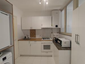 a white kitchen with white cabinets and a microwave at La Chicca nel Barocco - Modica Centro - Indipendente in Modica
