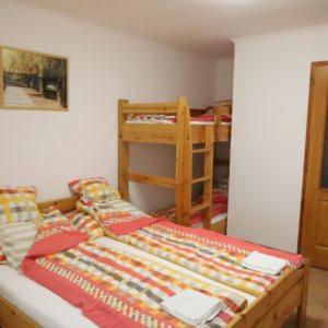 a bedroom with a bed and two bunk beds at Panoráma Szálláshely in Csongrád