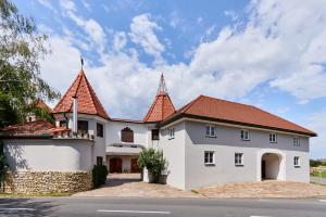 a white house with two towers on a street at Apartment im Schlössl in Leibnitz