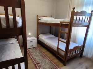 a room with two bunk beds and a rug at City Center Hostel in Shkodër