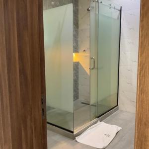 a glass shower in a bathroom with a towel on the floor at Roseann Gold Boutique Hotel in Kusafe +139 photos