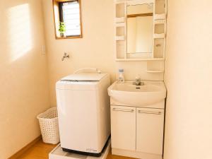 a small bathroom with a sink and a mirror at Hamabun テラスでBBQ 湖まで徒歩5分 無料駐車場3台 in Takashima +23 photos