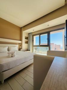 a bedroom with a bed with a teddy bear on it at Saradari Beach Hotel - Adults Only in Hersonissos