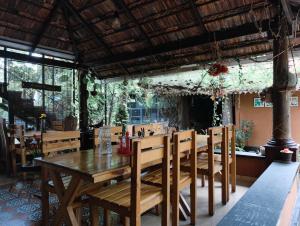 a dining room with a wooden table and chairs at Ambadi's villa -Lake view resort in Pallipuram