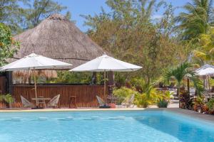 a swimming pool with chairs and umbrellas and a resort at Villas HM Paraiso del Mar in Holbox Island