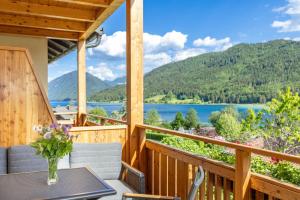 a porch with a table and chairs and a view of a lake at Appartement Lackner TOP 2 - Weissensee in Weissensee
