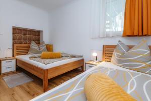 a bedroom with two beds and an orange curtain at Appartement Lackner TOP 2 - Weissensee in Weissensee