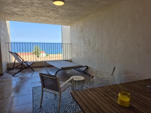 a room with a table and chairs and a large window at horizon bleu et détente in Saint-Florent