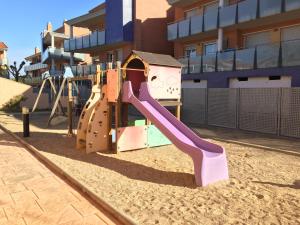 a playground with a slide in the sand at Apartamento Port Marino in Cambrils