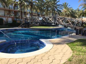 un puente sobre una piscina en un complejo en Apartamento Port Marino, en Cambrils