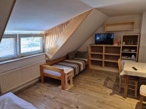 a room with a staircase with a couch and a tv at Relax Penzion U Adama in Dolná Tižina