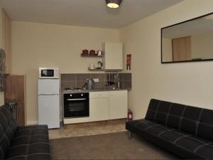 a living room with a couch and a kitchen at Hoppers Cottage Guest House in Newcastle upon Tyne