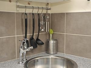 a kitchen counter with a sink and utensils on a wall at Hoppers Cottage Guest House in Newcastle upon Tyne