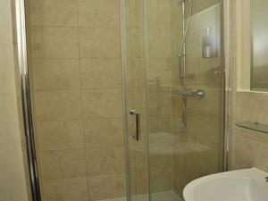 a shower with a glass door next to a toilet at Hoppers Cottage Guest House in Newcastle upon Tyne