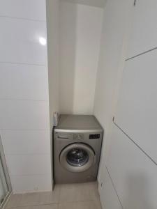 a small bathroom with a stainless steel washing machine at horizon bleu et détente in Saint-Florent