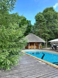 a house with a swimming pool and a gazebo at Secret River Rooms in Pereiaslav-Khmelnytskyi