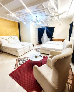 a living room with two beds and a red rug at The Eastern Lodge in Islamabad