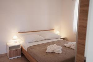 a bedroom with a bed with two white flowers on it at Oaza in Nerezine