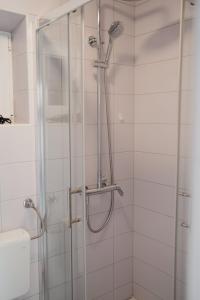 a shower with a glass door in a bathroom at Oaza in Nerezine