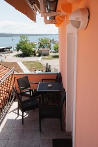 a patio with a table and chairs on a balcony at Oaza in Nerezine