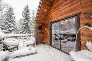 a cabin with a balcony covered in snow at Lodge 3 - LE JOLIS CHALETS in Barbey-Séroux