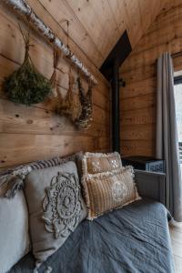 a bed in a room with a wooden wall at Lodge 3 - LE JOLIS CHALETS in Barbey-Séroux