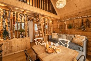 a dining room with a table in a log cabin at Lodge 3 - LE JOLIS CHALETS in Barbey-Séroux