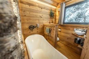 a wooden bathroom with a tub and a sink at Lodge 3 - LE JOLIS CHALETS in Barbey-Séroux +38 photos