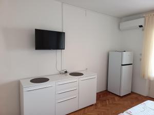 a kitchen with a white counter with a refrigerator at APARTMAN I SOBE MARIJANA in Rab
