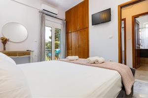 a bedroom with a white bed with towels on it at Achilleas Deluxe House-Jacuzzi - BBQ in Kotsianá