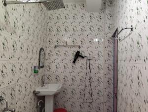 a bathroom with a sink and a shower in it at Relax Hotel in Bāghdogra