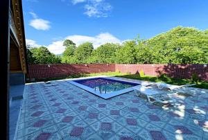 a backyard with a swimming pool and a patio at Qafqaz A-Frame Chalet Gabala in Gabala