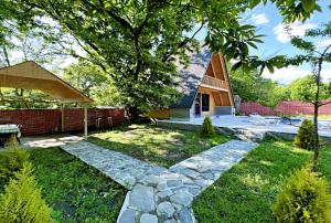 a garden with a stone path and a house at Qafqaz A-Frame Chalet Gabala in Gabala