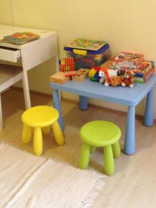デブレツェンにあるPéterfia Apartmanの部屋に玩具テーブルとスツール2脚