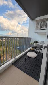 a balcony with a table and chair and a view of the ocean at studio MA-DE cozy Bacolod City in Bacolod