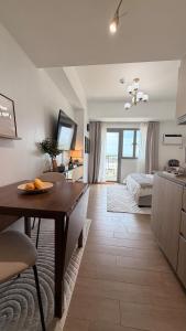 a kitchen and living room with a table and a bed at studio MA-DE cozy Bacolod City in Bacolod