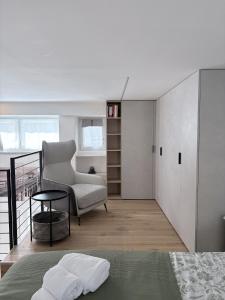 a bedroom with a bed and a chair at Monica's Loft in Domodossola
