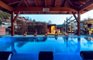 an outdoor swimming pool with a pavilion at Hotel MY Kramerwirt in Geiersthal
