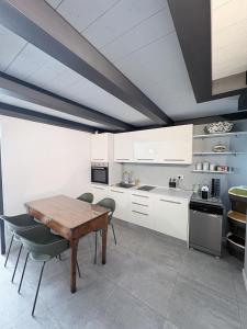 a kitchen with white cabinets and a wooden table at Monica's Loft in Domodossola