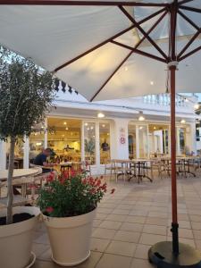 an umbrella in a restaurant with tables and chairs at Posidonia -Son Bou Apartment in Son Bou
