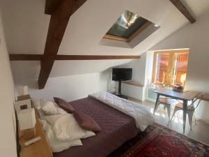 a bedroom with a bed and a desk and a table at Chez Rose-Laure in Grandviala