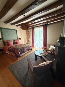 a bedroom with a bed and a couch and a table at Maison Romy in Chinon